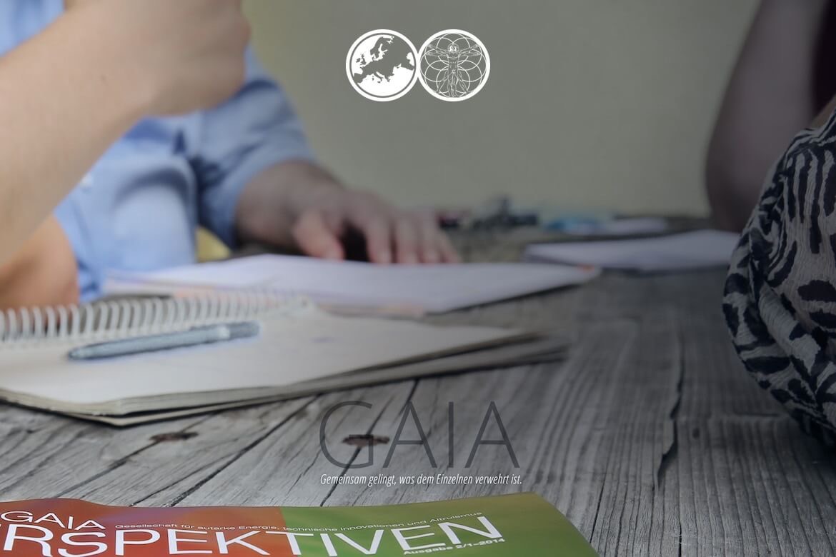 Mitglieder der GAIA-Gemeinschaft arbeiten gemeinsam an einem Tisch mit Notizbüchern und Unterlagen.